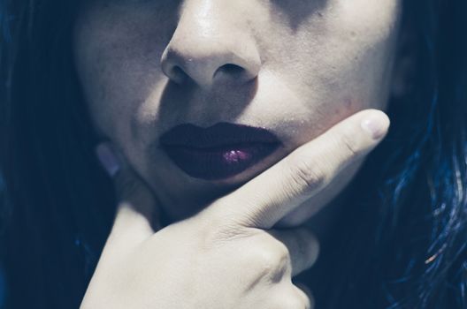 Portrait of only woman lips with hands touching in thoughtful expression