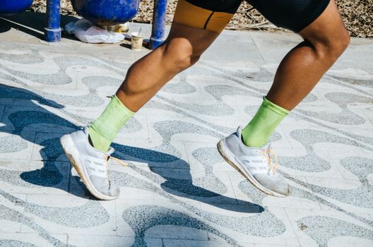 Sports background. Runner feet running on road closeup on shoe.