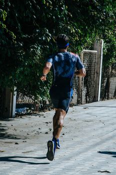 A man runner on the street doing exercises, image concept of sport and exercise