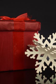 A closeup image of a red Christmas gift with decorative items to compliament the festive season.