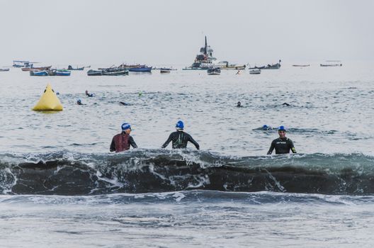 LIMA, PERU - APRIL 22th 2018: Ironman 70.3 . Athletes entering the sea and others leaving