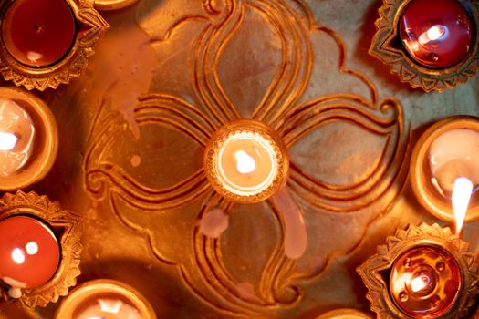 Macro shot showing colorful earthenware diya oil lamps with a little cotton wick to burn oil for light often used as decoration on the hindu festival of diwali showing the victory of good over evil. Shows the beautiful decorations on the hindu festival of diwali where small earthen lamps filled with oil are lit to show the victory of good over evil