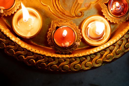 Half frame shot showing colorful earthenware diya oil lamps with a little cotton wick to burn oil for light often used as decoration on the hindu festival of diwali showing the victory of good over evil. Shows the beautiful decorations on the hindu festival of diwali where small earthen lamps filled with oil are lit to show the victory of good over evil