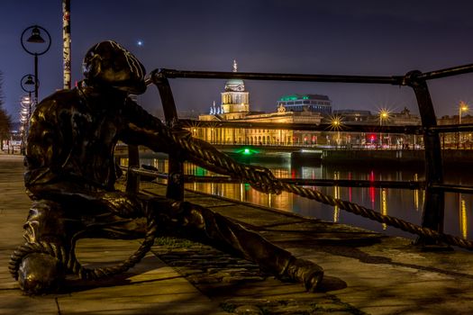 Sculpture of sailor pulling rope on River Liffey, Dublin, Ireland at night