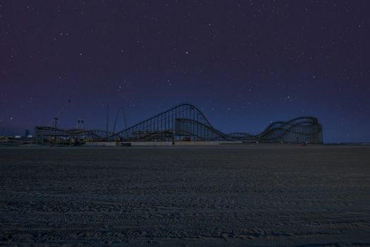 A Large Wooden Roller Coaster on Pier on a Beach in Wildwood New Jersey With a Star Filled Night Sky Behind It