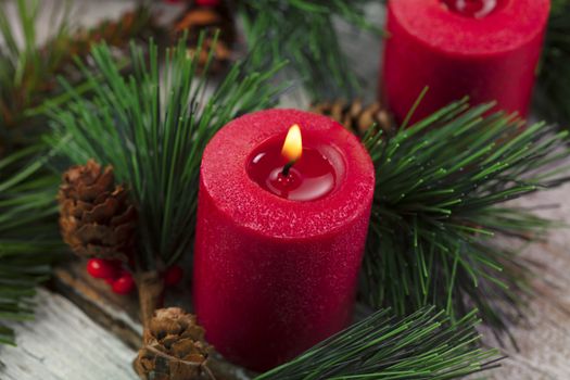 Close up of glowing red candle for the warm holiday season of merry Christmas 