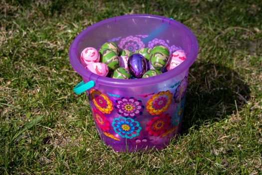 Easter basket with Bright pink and flowers full of Easter egg hidden in green grass . High quality photo