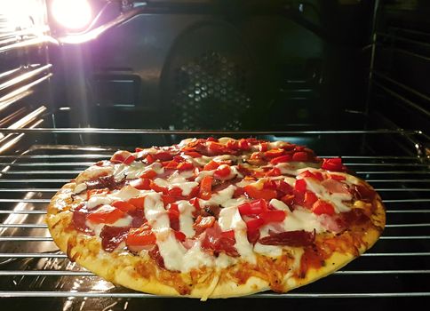 Baking homemade pizza in oven. The inside of an oven with fresh homemade baked pizza.