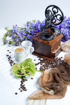 Coffee mill, cup and coffee beans on a studio background