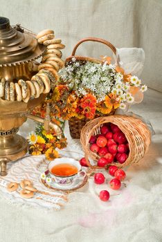 Russian traditional water boiler, flowers and berries on a studio background