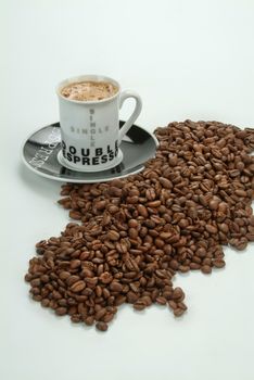 Cup of coffe, beans and tableware on a studio background