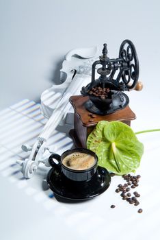 Coffee mill, cup and coffee beans on a studio background