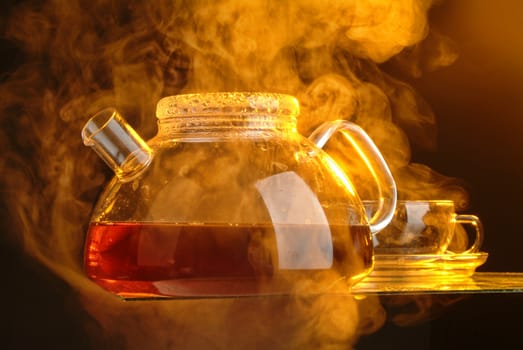 Glass tea pot and steam on a studio background