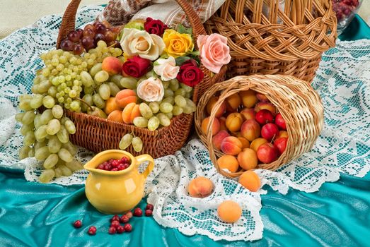 Wicker basket and different fruits on a studio background