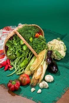 Wicker basket and vegetables on a studio background
