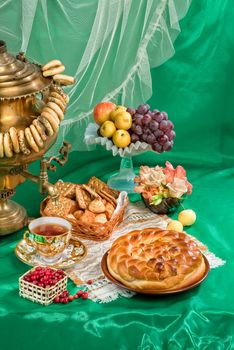 Russian traditional water boiler, fruits and bread on a studio background