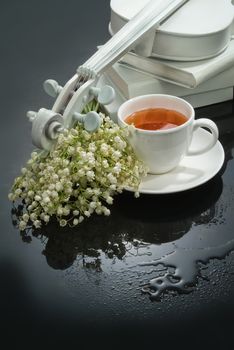 Cup of tea, violin and flowers on a glass background