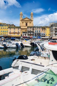 view on église Saint Jean-Baptiste in Bastia from the vieux port with some boats resting in the habour during summertime