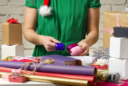 women select ribbons for wrapping gifts. diy Gift wrapping for Christmas and New Year. Handmade. packing and wrapping service concept