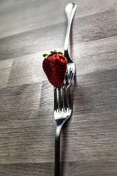 composition with strawberry and forks viewed in various perspectives on wooden table