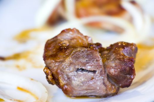 Georgian Mtsvadi on the white plate in restaurant, close-up and macro of meet