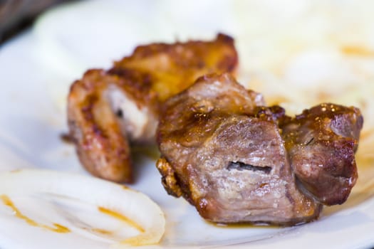 Georgian Mtsvadi on the white plate in restaurant, close-up and macro of meet