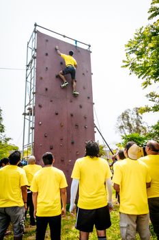 Free climber young man climbing artificial boulder indoors