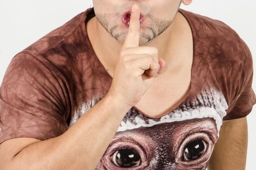 Finger on lips as man gesturing sign shh, please, silence concept, white background.
