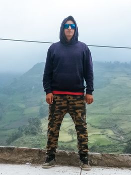 Hiker man trekking portrait in high mountain. Hiking male in alpine clothing hard shell jacket above in mountain above the clouds. Portrait of young man outdoorsman.