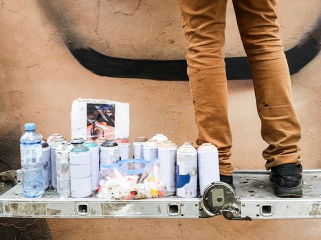 Young urban painter starting to draw graffiti on the wall