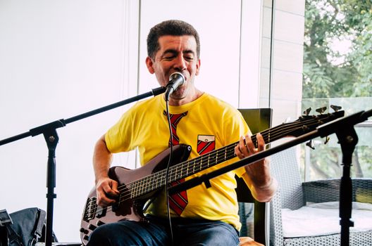 Handsome young musician playing the guitar and singing