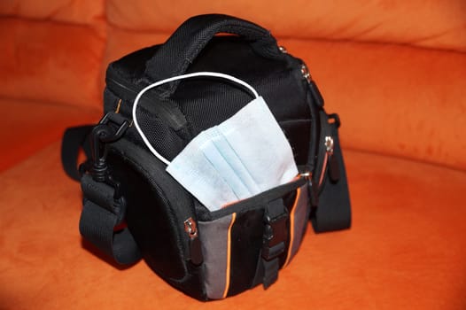 medical mask in camera bag close up.