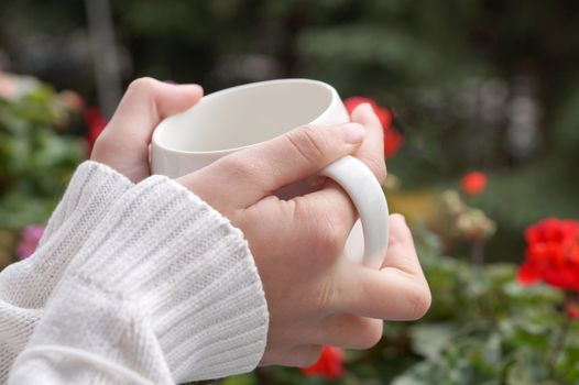 the girl's hands are warm from a hot cup close up