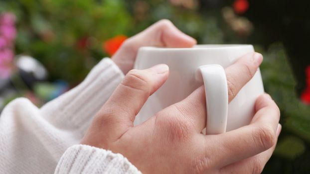 the girl's hands are warm from a hot cup close up