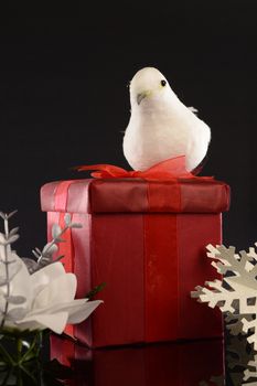 A closeup image of a red Christmas gift with decorative items to compliament the festive season.