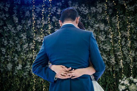 wedding couple performing first dance and hugging. luxury bride and groom embracing. tender sensual romantic moment at wedding reception in restaurant.