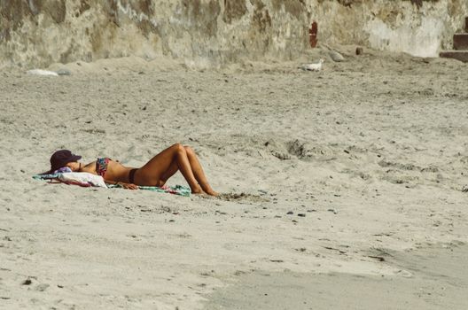 Young woman resting on the paradise beach and take sunbath