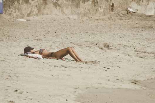 Young woman resting on the paradise beach and take sunbath
