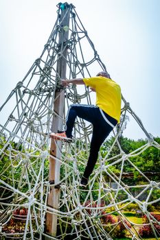 Man climbing the ropes on a sunny summer day