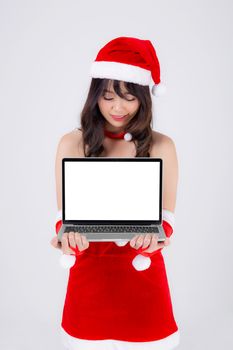 beautiful young asian woman in Santa presenting laptop computer in Christmas holiday isolated on white background, beauty asia girl holding showing notebook for celebrating in xmas day or new year.