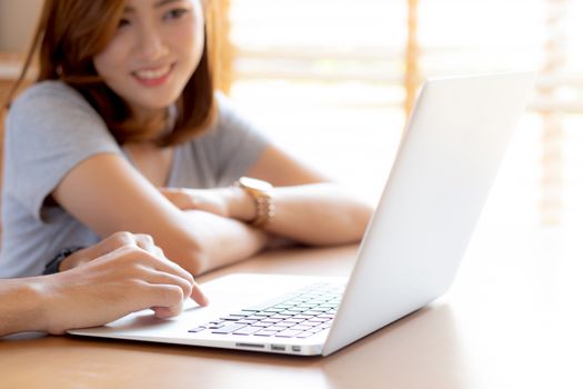 Asian young couple using laptop computer think and searching internet together, man and woman casual smiling work at home with happy and relax, communication and business concept.