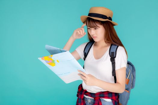 Beautiful portrait young asian woman travel holding and looking a paper map isolated on blue background, asia girl think and idea search journey with direction in vacation trip for leisure.
