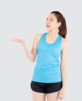Beautiful portrait young asian woman in sport with satisfied and holding and throw green apple isolated on white background, girl asia have shape and wellness, exercise for fit with health concept.