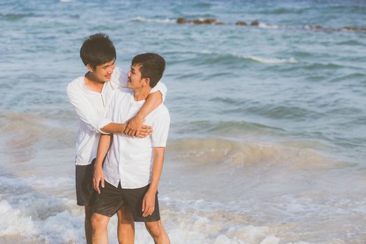 Homosexual portrait young asian couple standing hug together on beach in summer, asia gay going tourism for leisure and relax with romantic and happiness in vacation at sea, LGBT concept.