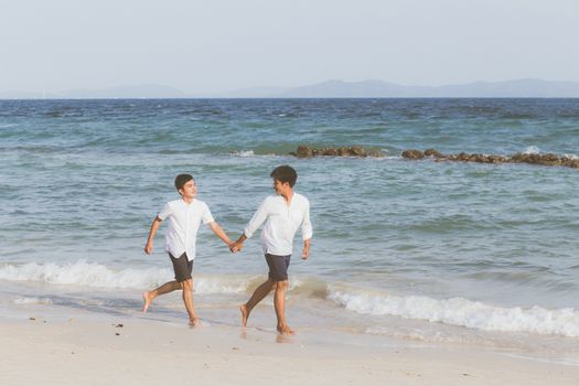 Homosexual portrait young asian couple running with cheerful together on beach in summer, asia gay going tourism for leisure and relax with happiness in vacation at sea, LGBT legal concept.