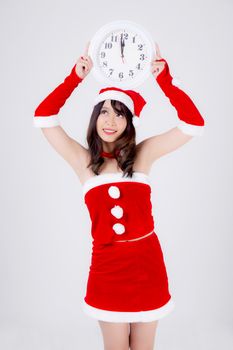 Beautiful portrait young asian woman in Santa dress holding clock with excited in xmas holiday isolated on white background, beauty asia girl celebrating success in festive Christmas day or new year.