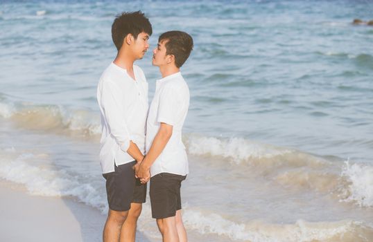 Homosexual portrait young asian couple standing together on beach in summer, asia gay holding hands going sea for leisure and relax with romantic and happy in vacation at sea, LGBT with legal concept.