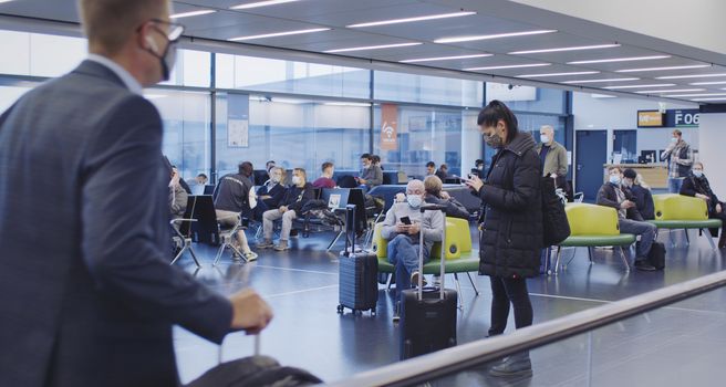 Vienna, Vienna/Austria - November 2nd 2020: Passengers walking to departure gates at Vienna airport. Only a few people travelling and a lot of closed gates.