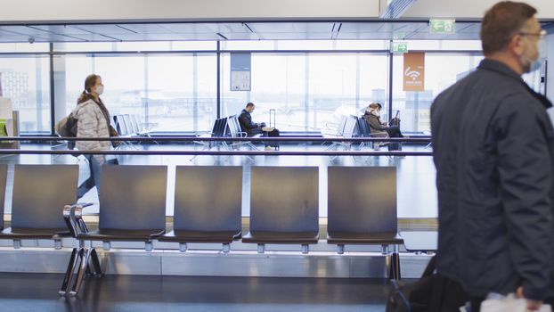 Vienna, Vienna/Austria - November 2nd 2020: Passengers walking to departure gates at Vienna airport. Only a few people travelling and a lot of closed gates.