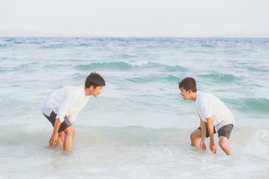 Homosexual portrait young asian couple play water on beach with cheerful together in summer, tourism of asia gay fun for leisure and relax with happiness in vacation at sea, LGBT legal concept.